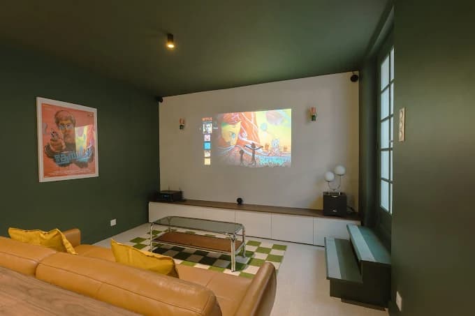 Salon avec home cinéma murs verts